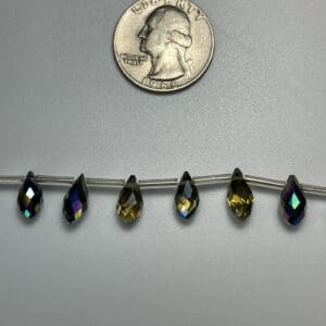 Six iridescent teardrop beads on wire.