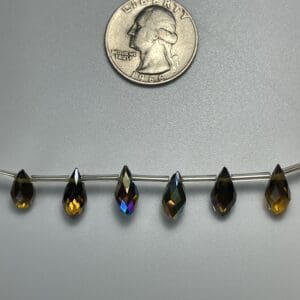 Six iridescent teardrop beads on wire.