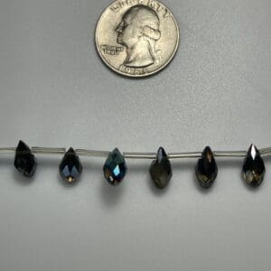 Dark teardrop crystals on wire.