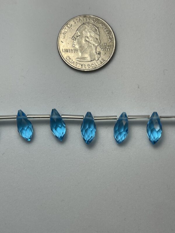 Blue faceted teardrop beads on wire.