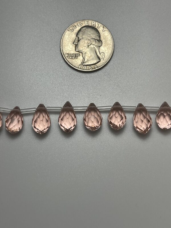 Pink crystal beads with quarter for scale.
