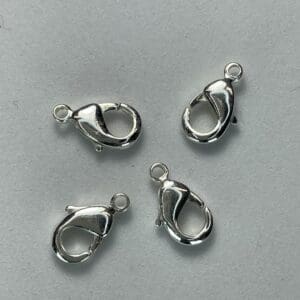 Four silver lobster claw clasps on gray.