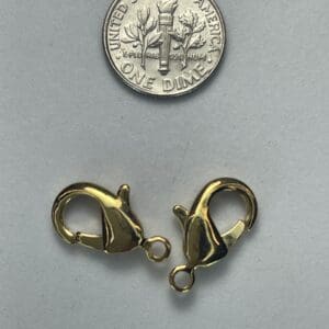 Gold clasps with a dime for scale.