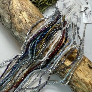 Colorful beaded strands on wooden surface.