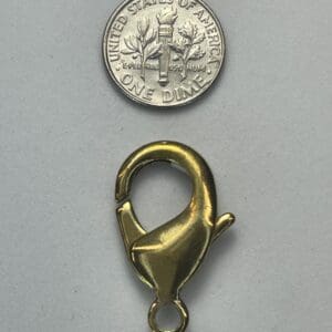 Gold lobster clasp and a U.S. dime.