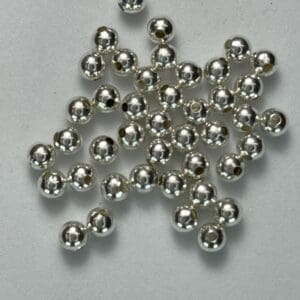Shiny silver beads scattered on surface.