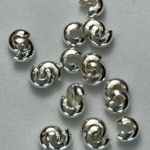 Silver spiral beads on a white background.