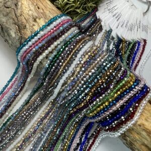 Colorful beaded strings draped over wood.