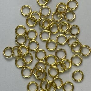 Gold metal rings scattered on white surface.