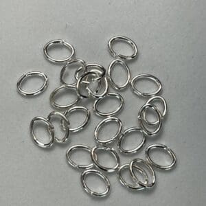 Silver oval metal rings scattered on surface.