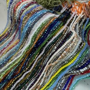 Colorful strands of beads displayed on table.