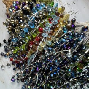 Colorful beaded pins scattered on surface.