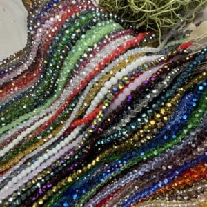 Colorful strands of beads next to green ball.
