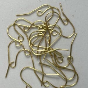 Gold earring hooks scattered on surface.