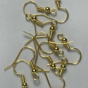 Gold earring hooks scattered on surface.