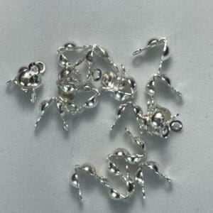 Silver jewelry components scattered on surface.