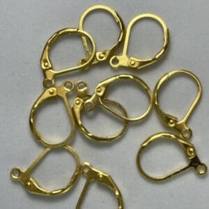 Gold earring clasps on a gray background.