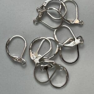 Silver earring clasps on a gray background.