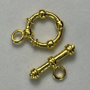 Gold toggle clasp on white background.