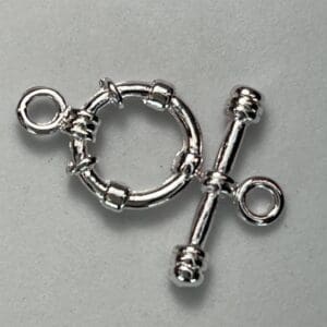 Silver toggle clasp on gray background.