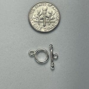 Dime and silver toggle clasp on display.