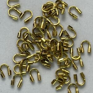 Gold hooks scattered on a gray background.