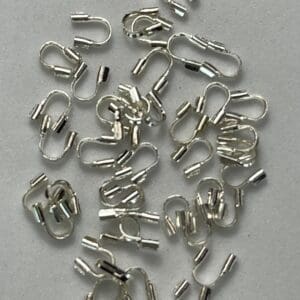 Silver metal wire guardians scattered on surface.