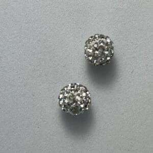 Two sparkly, silver bead earrings on display.