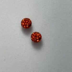 Two red textured beads on surface.