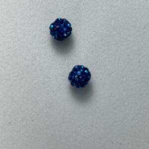 Two small, blue, textured beads on surface.
