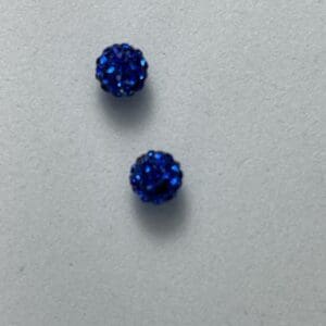 Two small sparkling blue ball-shaped earrings.