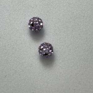 Two purple glittery round earrings.