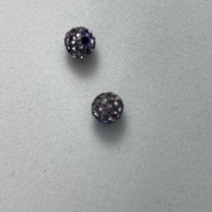 Two small, round, purple gemstone beads.