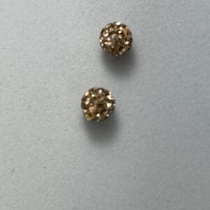 Two gold, textured earrings on surface.