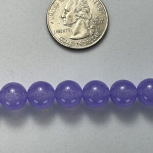 Purple beads with quarter for size.