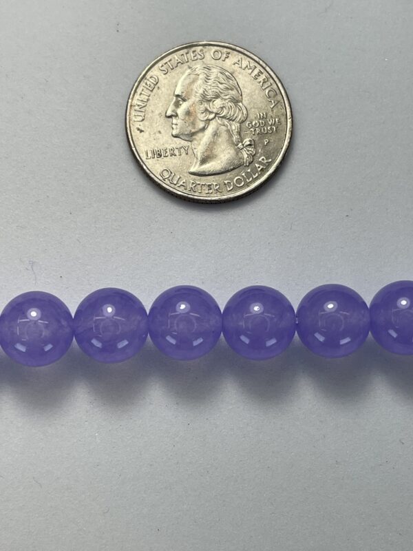 Purple beads with quarter for size.