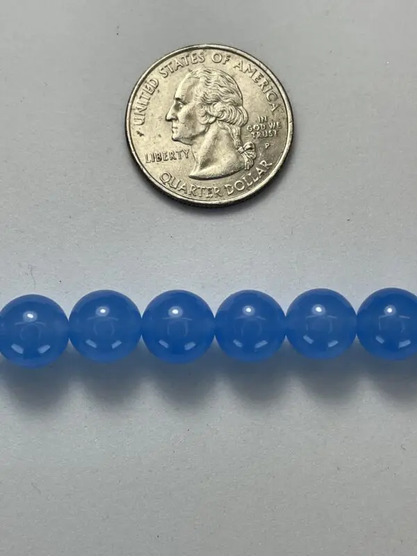 Light blue gemstone beads with quarter for scale.