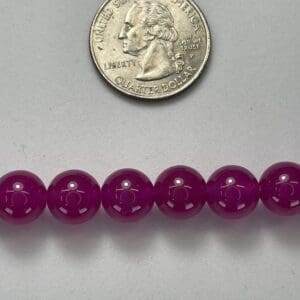 Purple beads with quarter for scale.