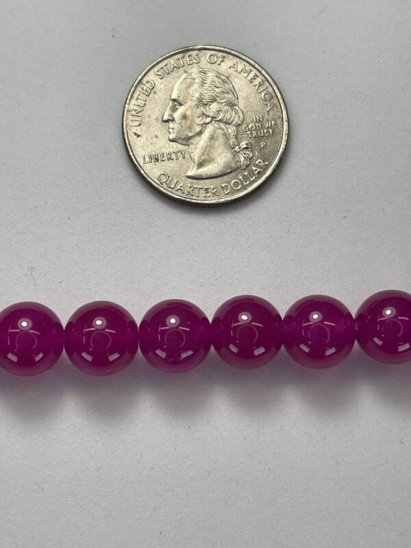Purple beads with quarter for scale.