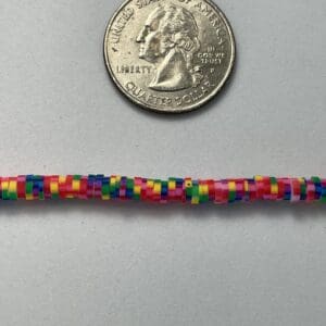 Quarter coin and colorful beaded bracelet.