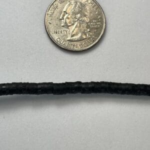 Quarter coin next to black cable.