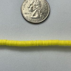 Yellow beads and a U.S. quarter coin.