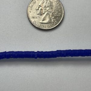 Quarter coin and blue beads on white.