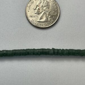 Quarter and strand of small green beads.