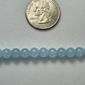 Light blue beads with quarter for scale.