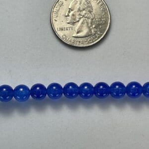 Blue beads with quarter for size.