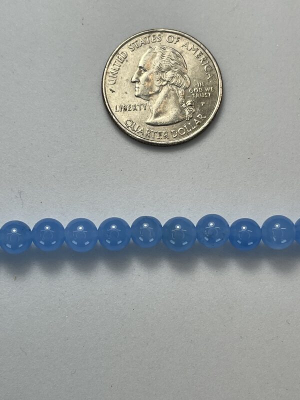 Light blue round beads with quarter for scale.
