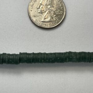 US quarter above dark green heishi disc beads