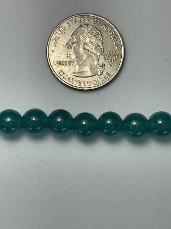Dark green beads next to quarter.