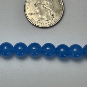 Blue beads with quarter for scale.